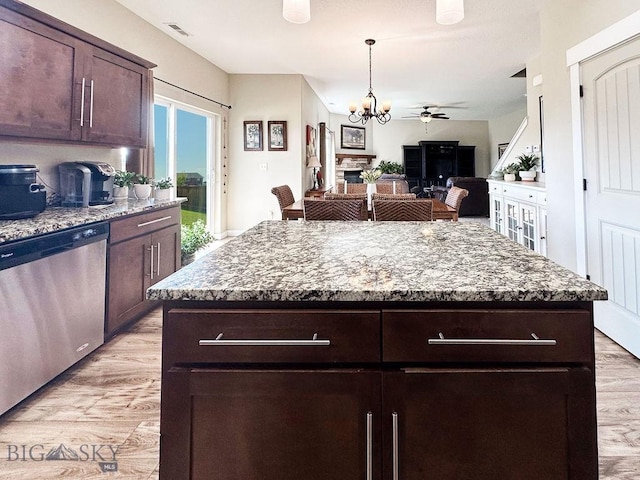 kitchen with dark brown cabinetry, visible vents, dishwasher, and a fireplace