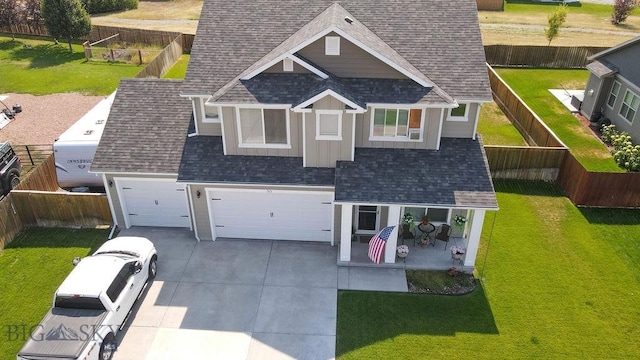 view of front of property featuring a fenced backyard, concrete driveway, a shingled roof, and a front yard