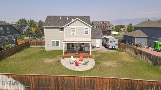 back of house with a mountain view, a patio, a lawn, and a fenced backyard