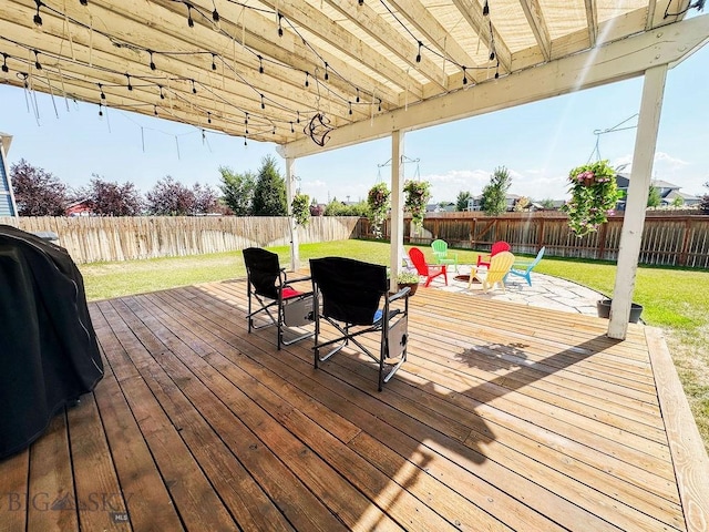 wooden terrace with a yard, a grill, and a fenced backyard