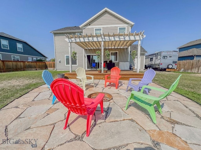 rear view of house with a lawn, a pergola, a patio, fence, and a fire pit