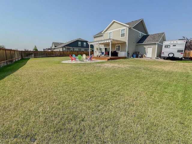 rear view of property with a fire pit, fence private yard, a lawn, a pergola, and a patio