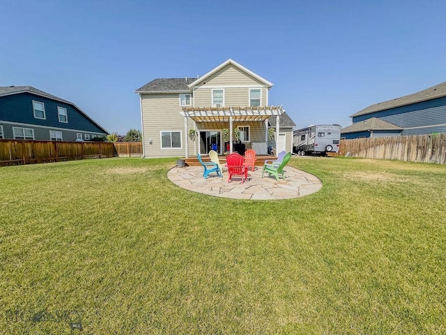 rear view of property featuring a lawn, a fenced backyard, a pergola, and a patio area