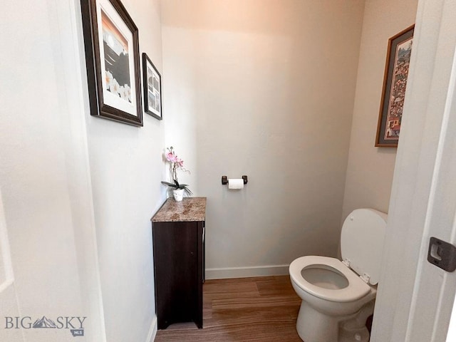 bathroom featuring baseboards, toilet, and wood finished floors