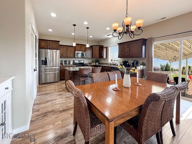 dining room featuring visible vents, light wood-style flooring, a toaster, recessed lighting, and a chandelier