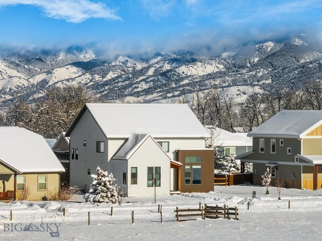 snow covered house featuring a mountain view