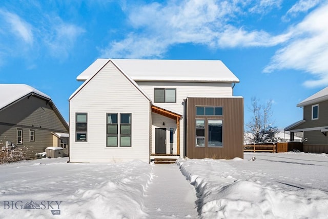 view of snow covered rear of property