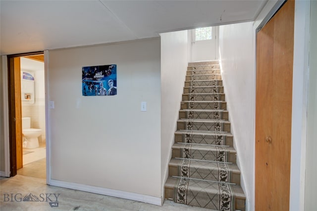 staircase featuring concrete floors