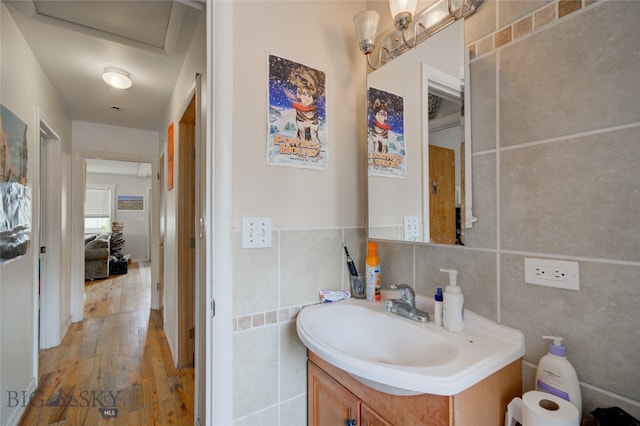 bathroom featuring vanity, tile walls, wood-type flooring, and decorative backsplash