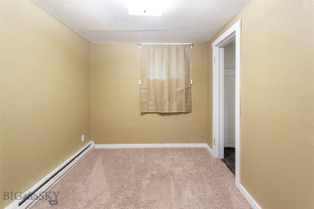 carpeted empty room with a textured ceiling and baseboard heating