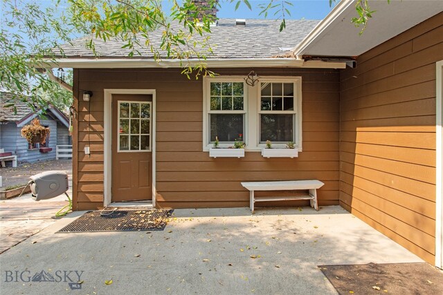 view of exterior entry with a patio area