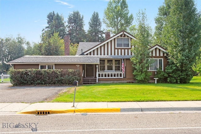 view of front of home with a front yard and a sunroom