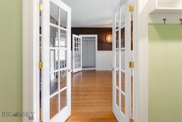 corridor featuring french doors and light hardwood / wood-style floors