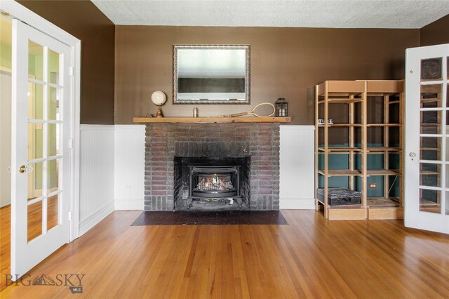 unfurnished living room with hardwood / wood-style floors, a fireplace, and a textured ceiling