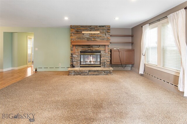 unfurnished living room featuring a baseboard radiator, carpet floors, and a fireplace