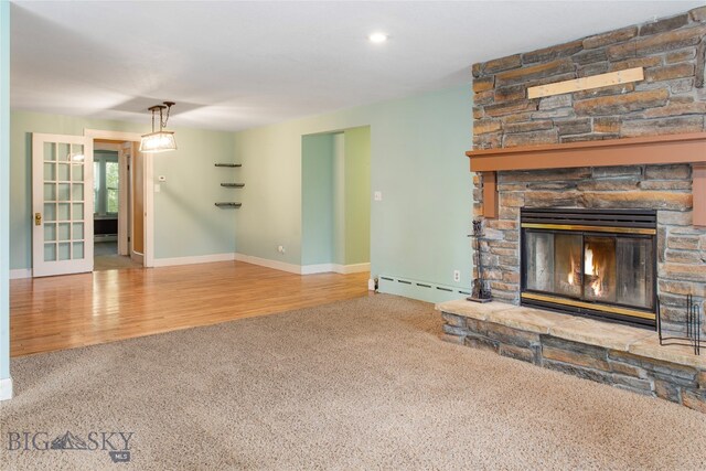 unfurnished living room with a fireplace, french doors, a baseboard heating unit, and wood-type flooring