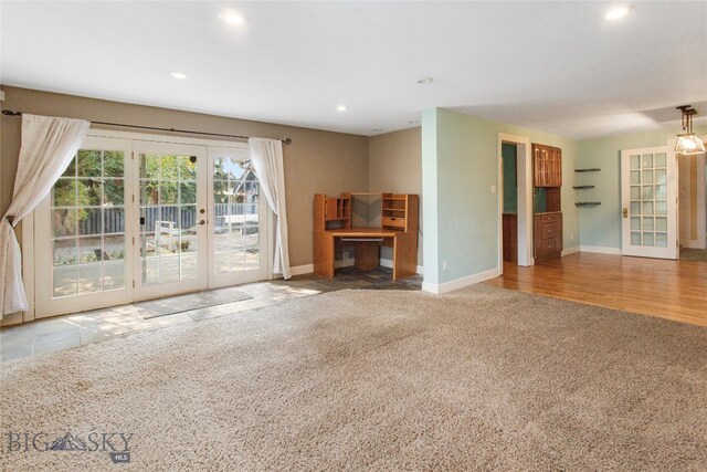 unfurnished living room featuring french doors and carpet floors