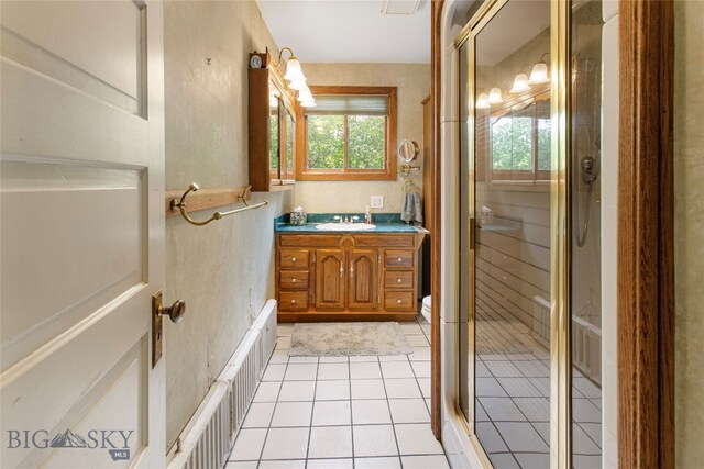 bathroom with vanity, a shower with shower door, and tile patterned flooring