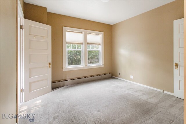 empty room with light colored carpet and baseboard heating