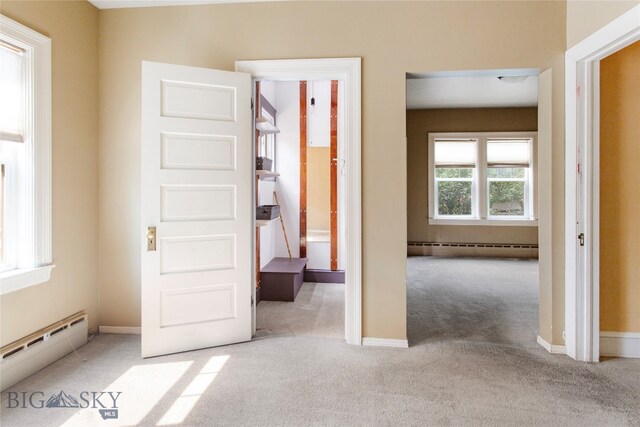 interior space featuring a baseboard heating unit and light carpet