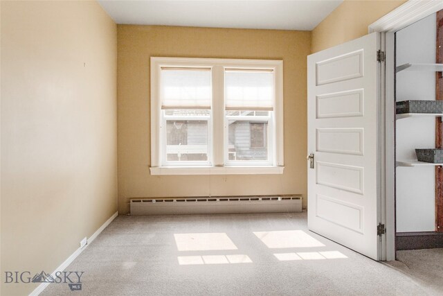 unfurnished room with a baseboard heating unit