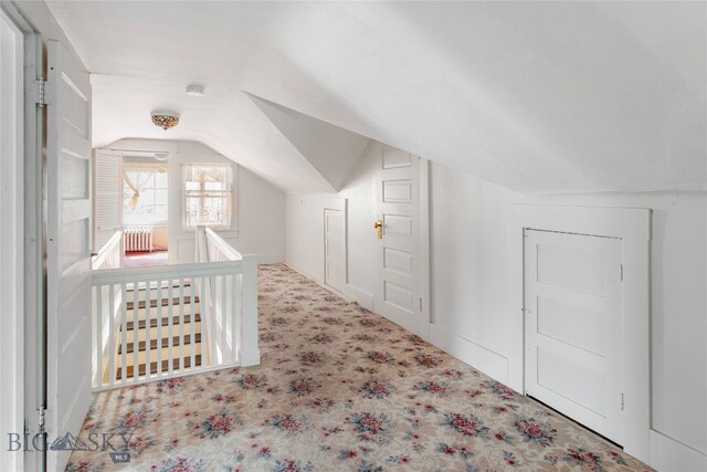 bonus room with carpet flooring, radiator, and vaulted ceiling