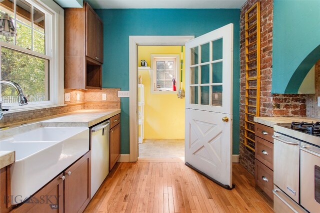 kitchen with stainless steel appliances, sink, and light hardwood / wood-style floors