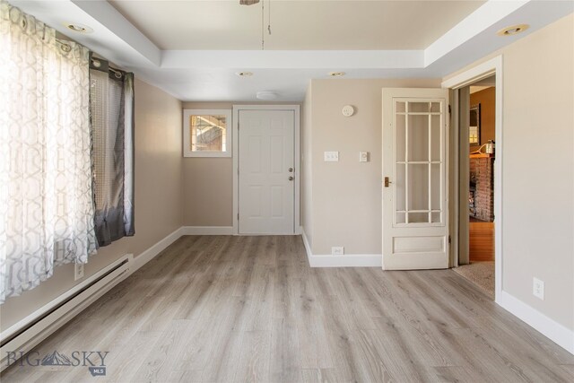 spare room with a baseboard heating unit and light wood-type flooring