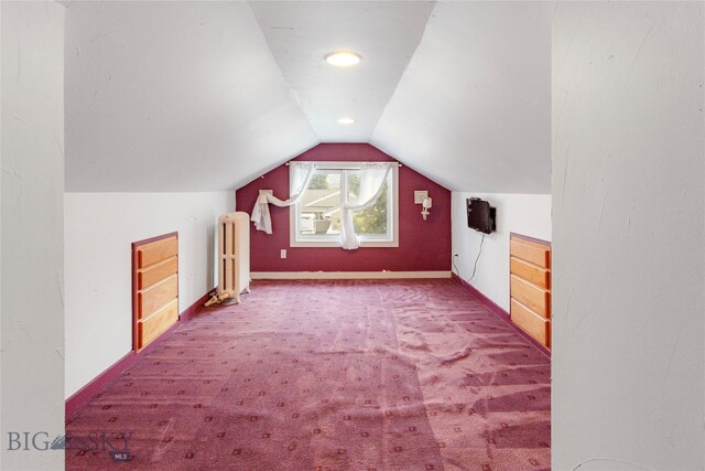 bonus room featuring radiator heating unit, vaulted ceiling, and carpet