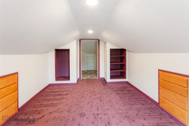 additional living space featuring vaulted ceiling and carpet floors