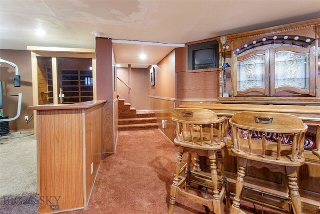 carpeted dining room featuring indoor bar