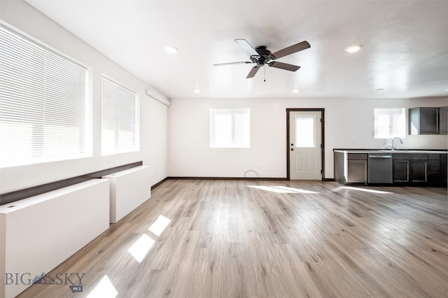 unfurnished living room with ceiling fan, light hardwood / wood-style floors, and a healthy amount of sunlight