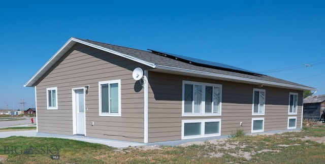 view of home's exterior with a lawn and solar panels