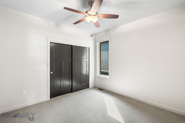 unfurnished bedroom with light carpet, ceiling fan, and a closet