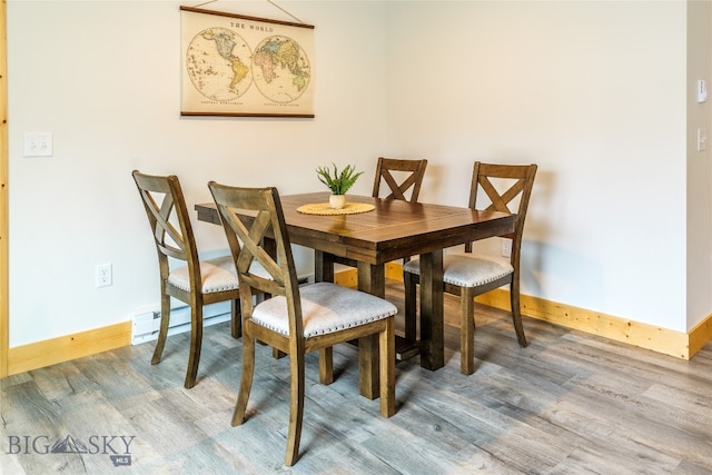 dining space featuring wood-type flooring and a baseboard radiator