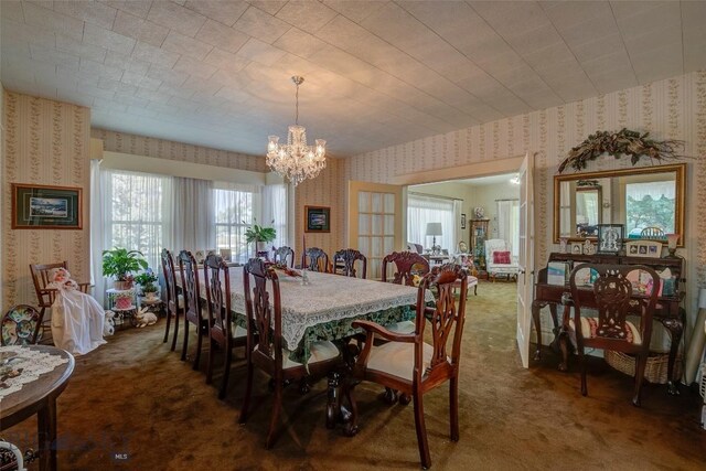 dining room with dark carpet and a chandelier