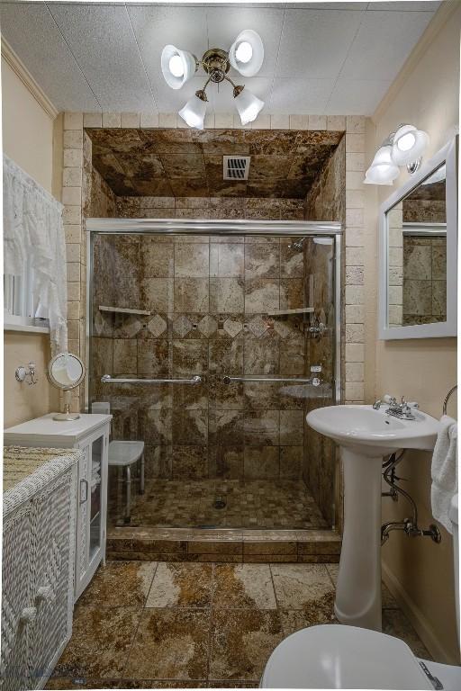 bathroom featuring ceiling fan, toilet, ornamental molding, and a shower with shower door