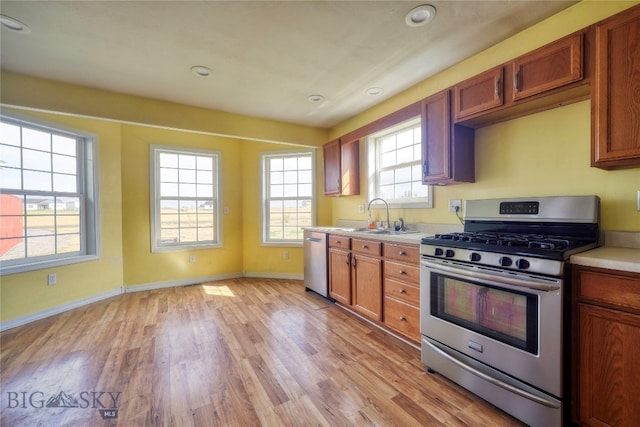 kitchen with stainless steel appliances, light hardwood / wood-style floors, and sink