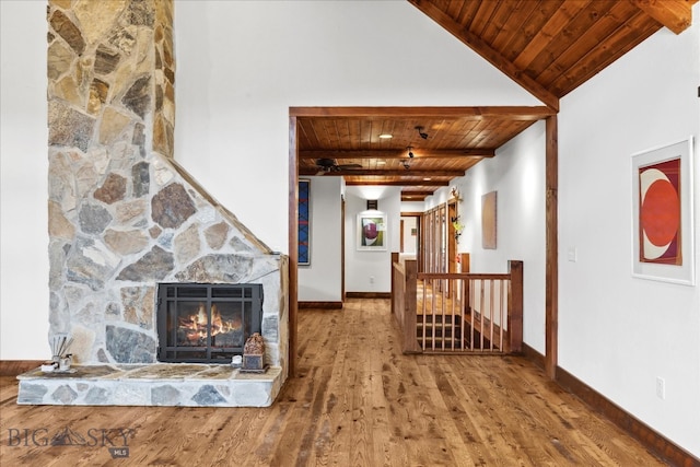 living room with a stone fireplace, wooden ceiling, lofted ceiling, and wood-type flooring