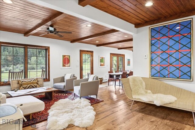 living room featuring beam ceiling, ceiling fan, wood ceiling, and light hardwood / wood-style floors