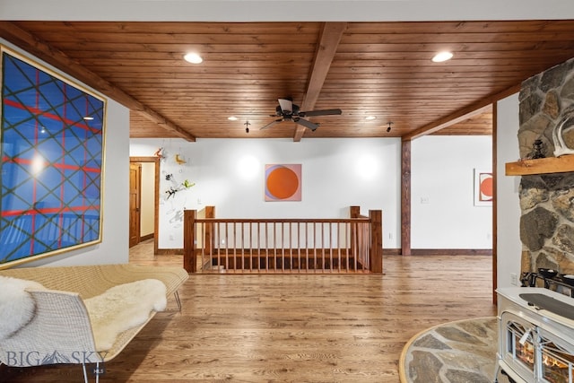 living area featuring hardwood / wood-style flooring, ceiling fan, beam ceiling, and wood ceiling