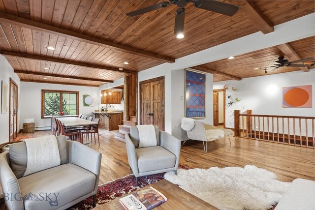 living room featuring beamed ceiling, wooden ceiling, a baseboard radiator, and light wood-type flooring