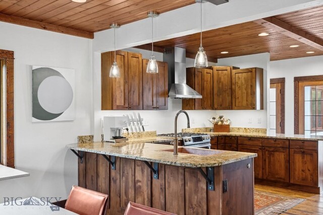 kitchen featuring kitchen peninsula, wall chimney exhaust hood, wooden ceiling, and decorative light fixtures