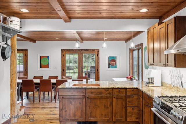 kitchen with wooden ceiling, beamed ceiling, kitchen peninsula, decorative light fixtures, and high end stainless steel range