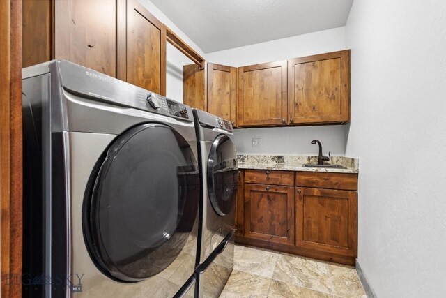 laundry room featuring cabinets, independent washer and dryer, and sink