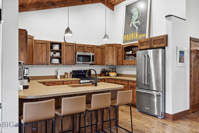 kitchen featuring beamed ceiling, a breakfast bar, wooden ceiling, and appliances with stainless steel finishes