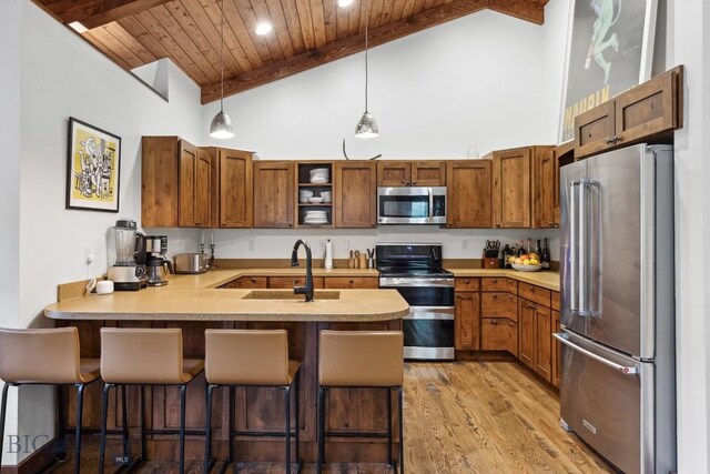 kitchen featuring hanging light fixtures, kitchen peninsula, a kitchen bar, wood ceiling, and appliances with stainless steel finishes