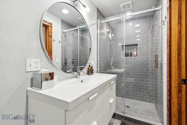 bathroom with tile patterned floors, vanity, and a shower with door