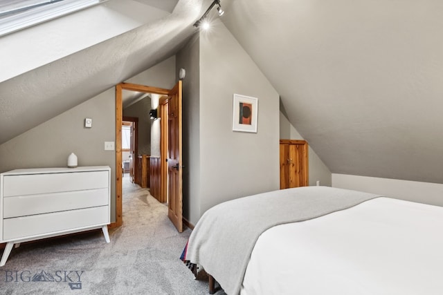 bedroom featuring light colored carpet and vaulted ceiling