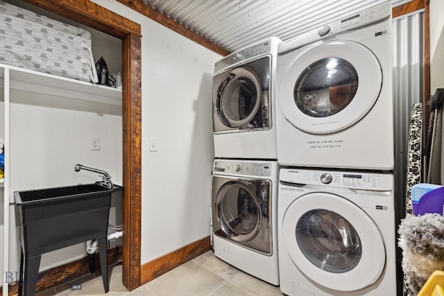 washroom with light tile patterned floors and stacked washer and clothes dryer